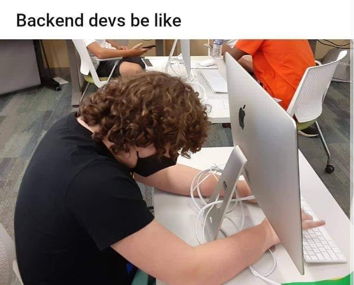 A photograph of a back-end developer facing the back of a computer monitor